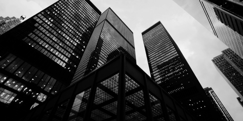 Looking up from the ground to 3 big business buildings.