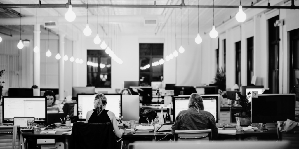 People working at a desk in an office, agency type setting.