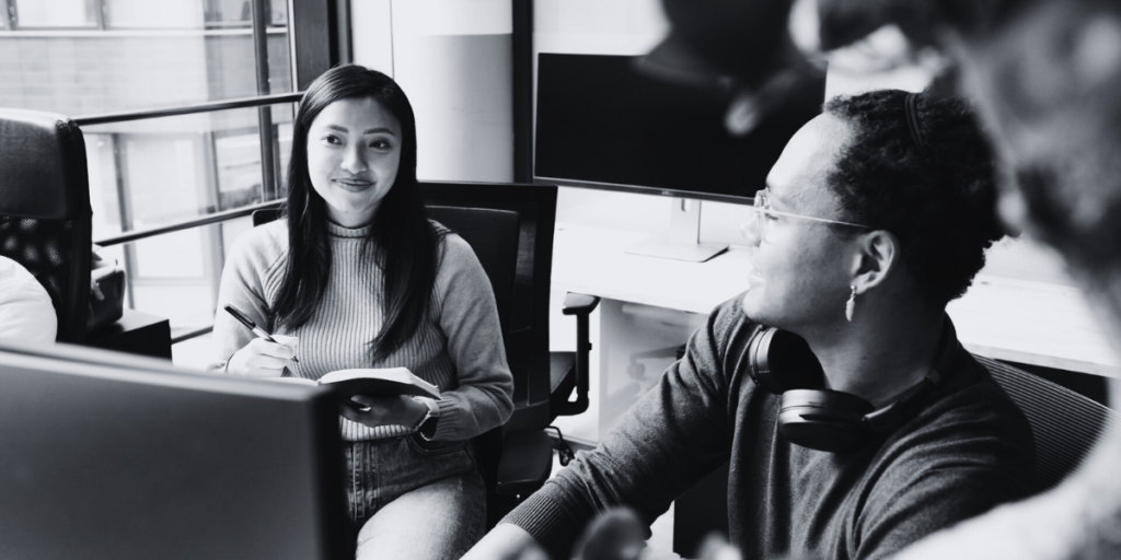 A smiling Asian woman and her African coworker.